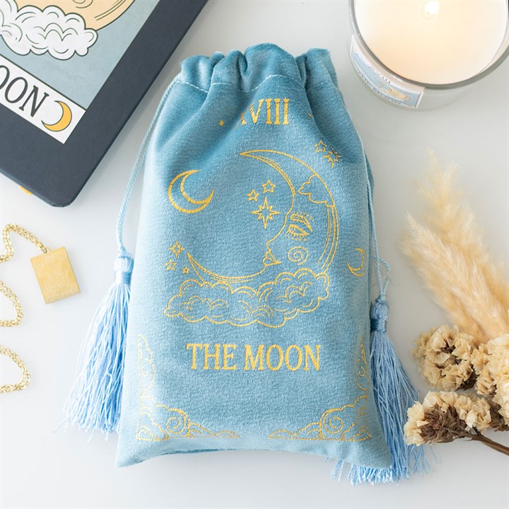 Bolsa de terciopelo azul claro para cartas de tarot con el diseño de La Luna en dorado y cordones con borlas.